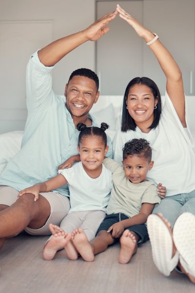 Family, roof and hands together for portrait on bedroom floor for insurance, support bonding and quality time. Security, protection and happy parents with children for love or safety in family home.